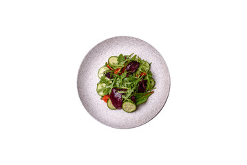 Delicious fresh salad with arugula, spinach, cucumber and cherry tomatoes in a ceramic plate