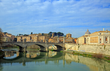 Scenic view over the River Tiber with reflection of arched bridge and Vatican Basillica in the distance, Rome, Italy