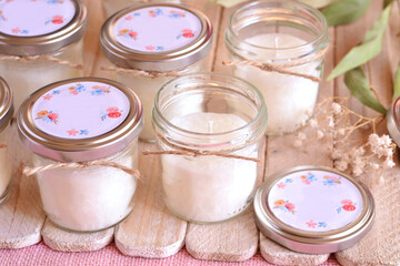 Wedding favors glass jar custom candles for party guests on favor wood table, personalized floral...
