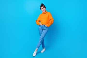 Full length photo of dreamy positive woman dressed orange sweater looking empty space isolated blue...