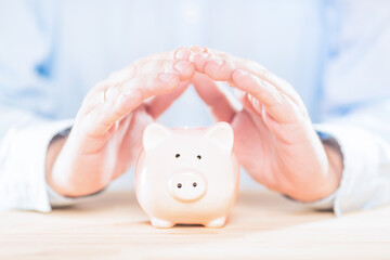 Saving money. Accounting, business, budget and finance concept. Male hands above piggy bank