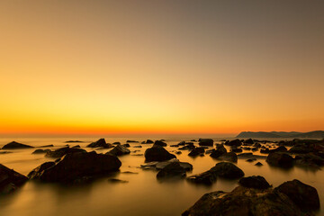 Sunset over the coast with stones of Black Sea, Russia