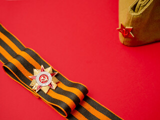 Victory Day 1945. The holiday is May 9th. St. George ribbon and medal on a red background with a...