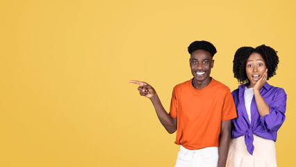 An animated young man in an orange shirt points to the side while a surprised young woman