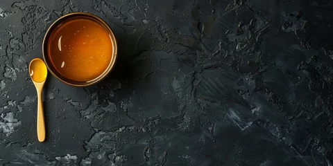 Fotobehang Honey in a glass jar on a black background. Copy space. © PhotoFlex
