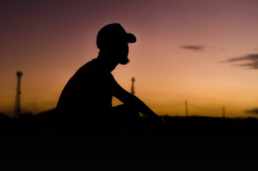 Silhouette of a young man watching the sunset