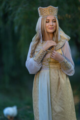 Portrait of a beautiful girl wearing a crown and traditional Russian style and holding a sword.