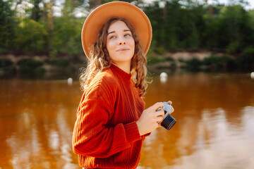 Woman photographer with a mirror film camera posing on a nature.Travel blog. Adventure, vacation...