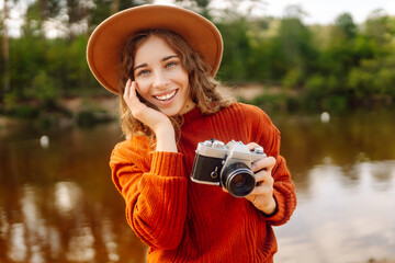 Woman photographer with a mirror film camera posing on a nature.Travel blog. Adventure, vacation...