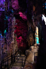Fototapeta na wymiar Natural cave with stalactites and stalagmites with lighting.