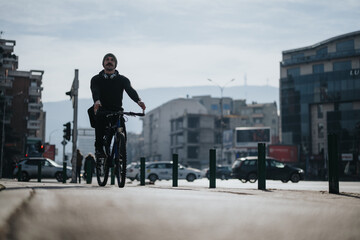 A focused man cycling on a city street with cars and urban buildings in the background, portraying...