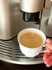 cup of coffee from the coffee machine in hand