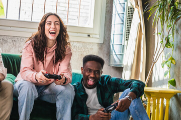 laughing friends playing video games together in a cozy room