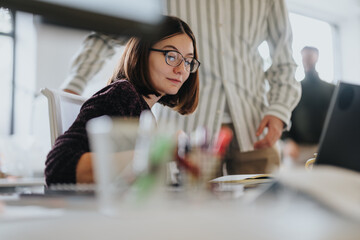 Diverse professionals collaborate on a business project, discussing reports and brainstorming ideas for success.