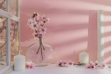 Présentation pour arrière plan de fleurs d'amandiers et de bougies sur un fond rose. Décoration pour un mariage, naissance, baptême.