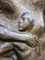 Fototapeta na wymiar bas-relief figure of a girl on metal