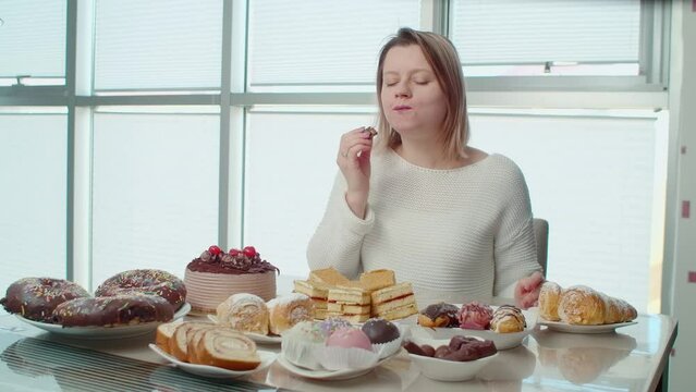 Woman eating sweet food, chocolate eclair and feel toothache. Problem with teeth after eating a lot of sugar, dentist is needed. Young woman with addiction to sugar suffering from problems with enamel