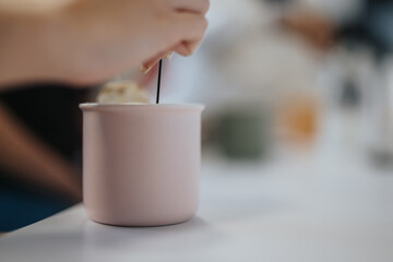 Woman resting from work. She stirs the sugar in her coffee. Close up shot.