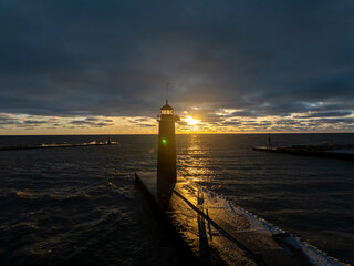 lighthouse at sunset overlooking Lake Michigan on a gloomy day the sun shines bright through the lighthouse glass