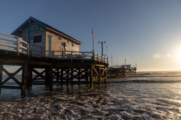 Fototapeta na wymiar Sunrise on Argentina Beach with a view of the Dock