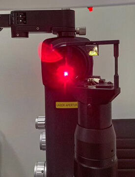 In an ophthalmologist office, the red light aiming device of an Nd:YAG laser unit: neodymium-doped yttrium aluminum garnet, used for medical procedures.
