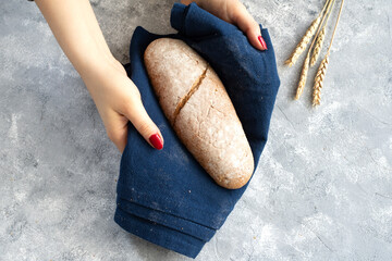 Woman hand holding freshly baked bread. Top view.