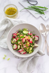 Healthy radish and cucumber salad with  dressing and green onions