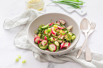 Healthy radish and cucumber salad with  dressing and green onions