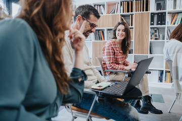 Creative team collaborating in modern office space with laptops and smiling faces.