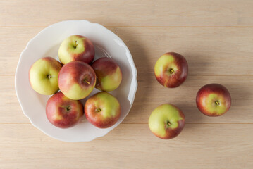 Fresh apples in white plate on wooden background - 747566026