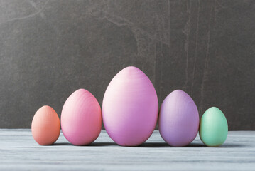 Colored Eggs of Different Sizes on Grey Background - 747566499