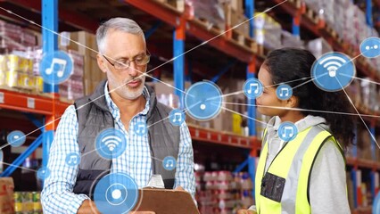 Animation of network of connections with icons over diverse workers talking in warehouse - Powered by Adobe