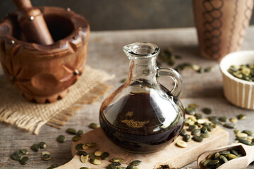 Dark pumpkin seed oil in a glass jug