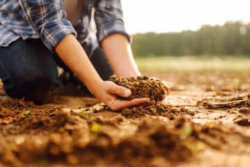 Farmer holding soil in hands close-up. Ecology, agriculture concept.
