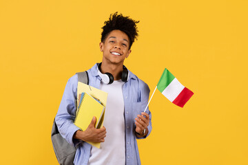 Joyful black student guy with Italian flag, ready for study abroad