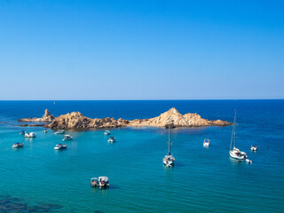 Sailboats in the turquoise sea of Cala Pregonda, Menorca