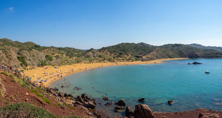 Panorama of the red sand beach Platja de Cavalleria, Menorca