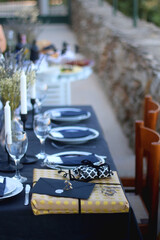 Wrapped present and card on set table. Party detail. Selective focus.