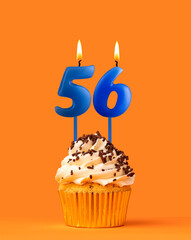 Blue candle number 56 - Birthday cupcake on orange background