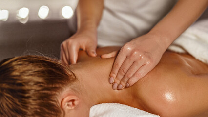 Obraz na płótnie Canvas Masseur making therapeutic neck massage for girl