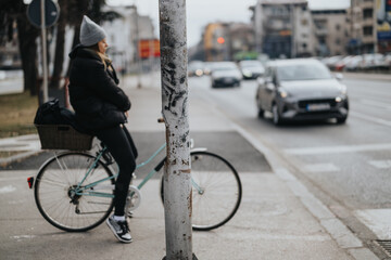 A female cyclist leaning on a post at a busy city intersection, contemplating urban life while cars...