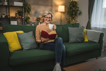 Obraz premium One woman mature caucasian female read book at home wear eyeglasses