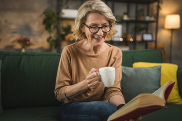 One woman mature caucasian female read book at home wear eyeglasses