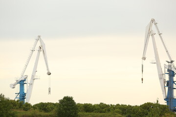 View of cranes in port at evening time