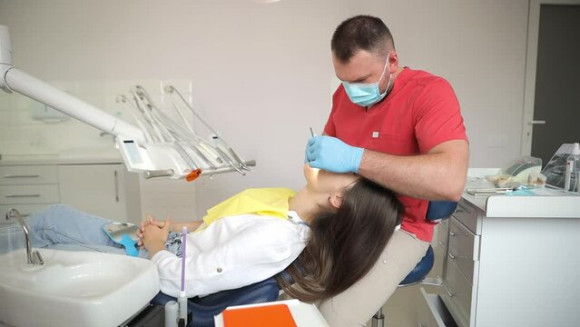 Woman getting dental service in a professional dentist's cabinetry.