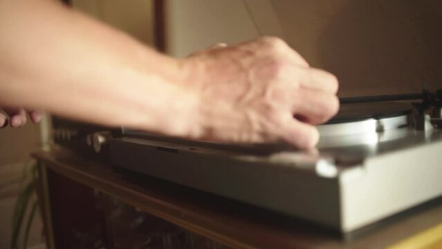 A man places the needle of a turntable on a record.