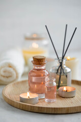 Aromatherapy, home decor concept. Glass perfume bottle, elegant composition with spring flowers. Burning candles, spa setting, essential oils, organic pure aromatic ingredients, atmosphere of relax