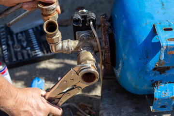 Dismantling the water distribution unit of the hydraulic tank of the water station for repair. Unscrewing the check valve