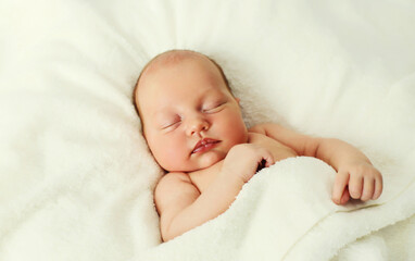 Portrait of infant sweet sleeping lying on white bed at home
