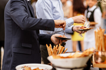 Obraz na płótnie Canvas Hommes se servant à manger au buffet